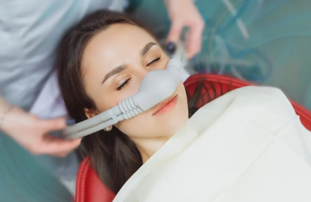 A patient relaxing in a dental chair with a nitrous oxide nosepiece.
