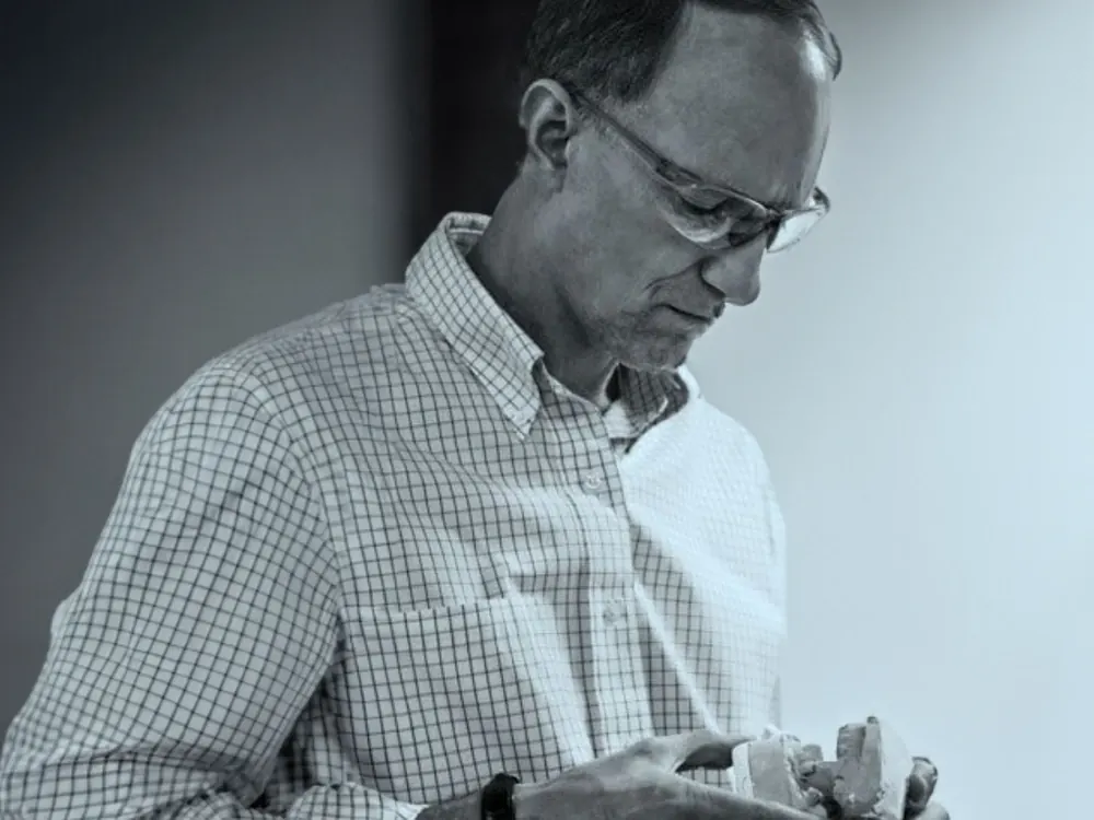 Dr. Douglas Pohl examining a dental model in his office.